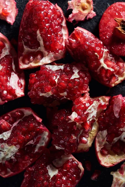 Top view of fresh cut pomegranates on black surface — Stock Photo