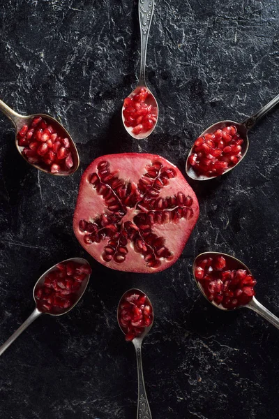Flat lay with spoons and cut pomegranate — Stock Photo