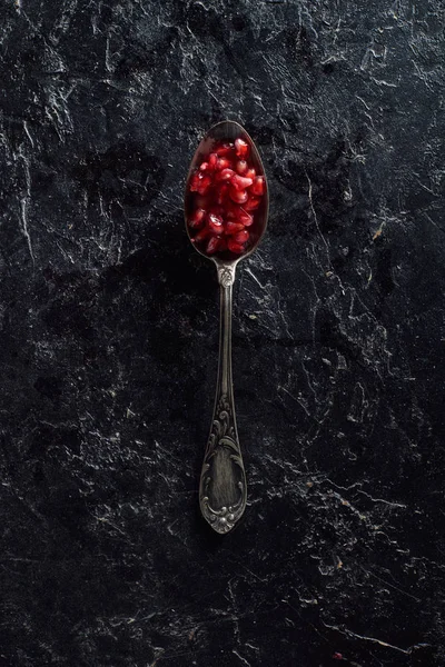 Vista dall'alto di cucchiaio vintage con semi di granato — Foto stock