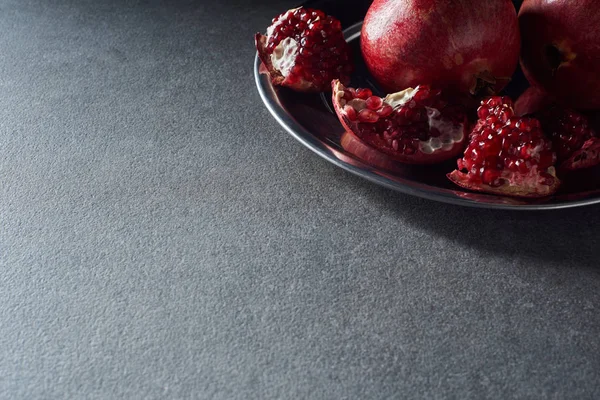 Studio shot of ripe cut garnets on plate — Stock Photo