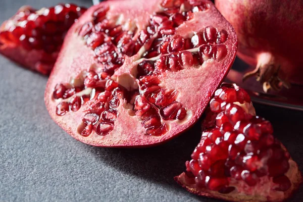 Close up shot of fresh cut garnets on grey surface — Stock Photo