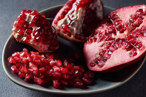 Close up shot of cut garnet and seeds in metal bowl — Stock Photo