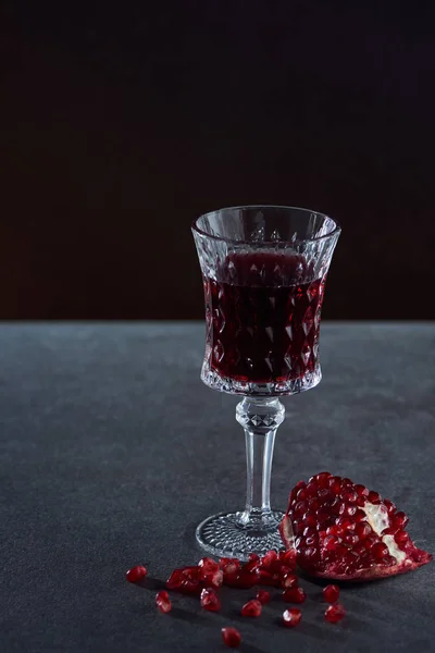 Studioaufnahme eines Weinglases mit Granat auf dunklem Hintergrund — Stockfoto