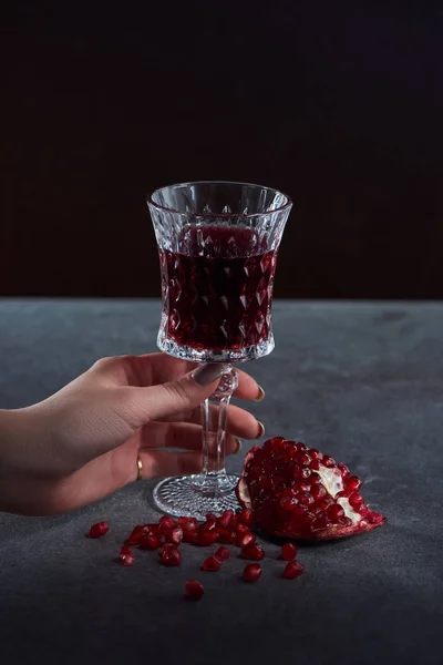 Partial view of woman holding wineglass of garnet juice — Stock Photo