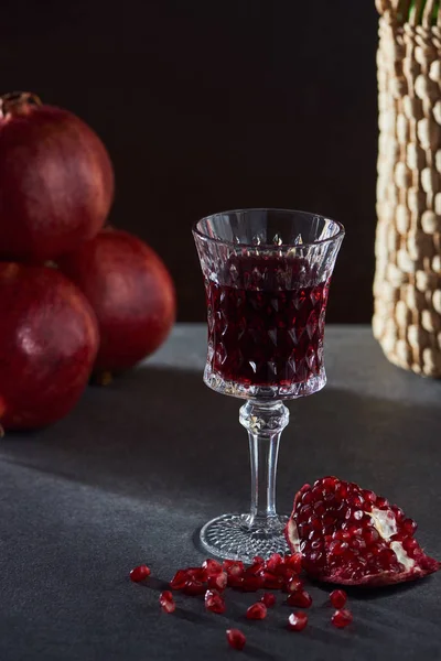 Studio shot of wineglass with wine and garnets — Stock Photo