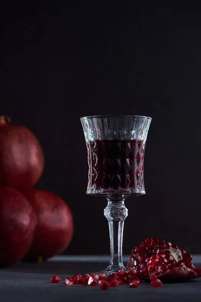 Studio shot of wineglass and ripe garnets — Stock Photo