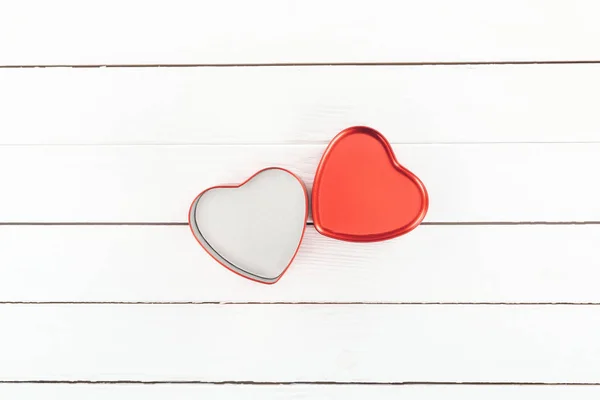 Вид зверху на червону коробку у формі серця на білому дерев'яному фоні, концепція дня Святого Валентина — стокове фото