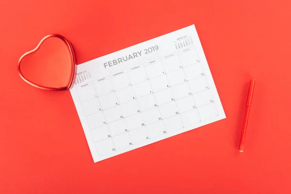Vista superior de la caja en forma de corazón y febrero 2019 calendario aislado en rojo, San Valentín concepto de día - foto de stock