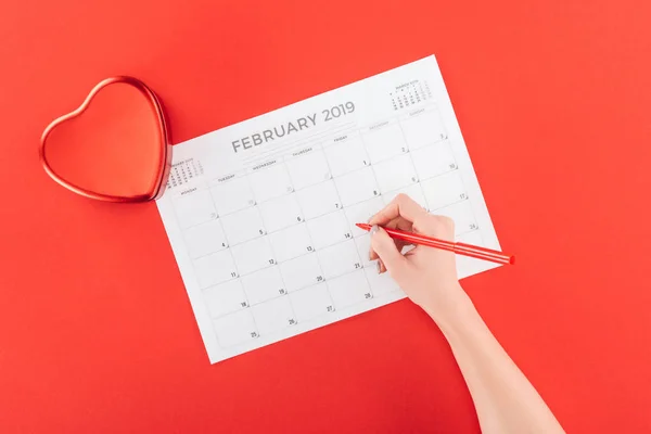 Vista cortada de mulher segurando marcador sobre fevereiro 2019 calendário isolado no vermelho, st Valentim dia conceito — Fotografia de Stock