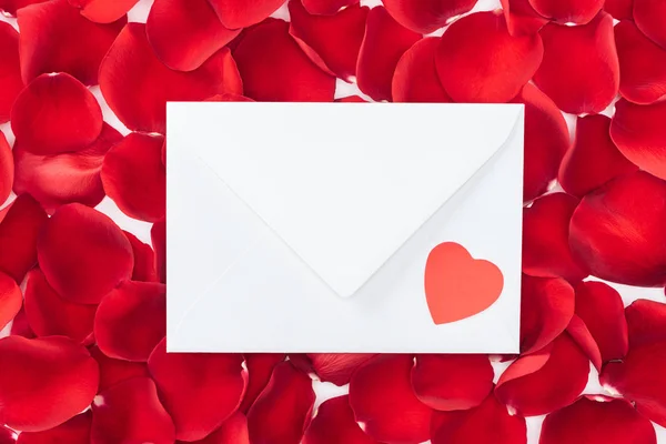 Vista superior do envelope com coração e pétalas de rosa vermelha no fundo, o conceito do dia de São Valentim — Fotografia de Stock