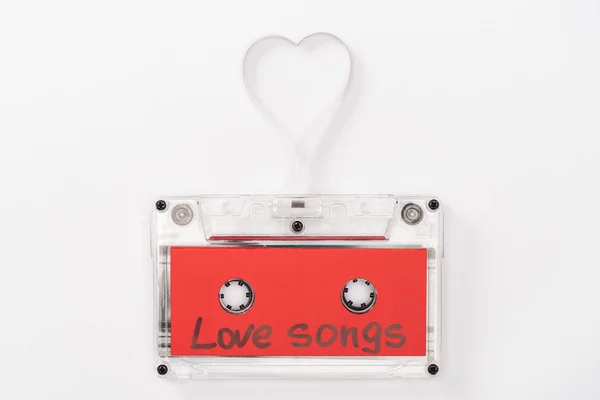 Top view of audio cassette with 'love songs' lettering and heart symbol isolated on white, st valentines day concept — Stock Photo