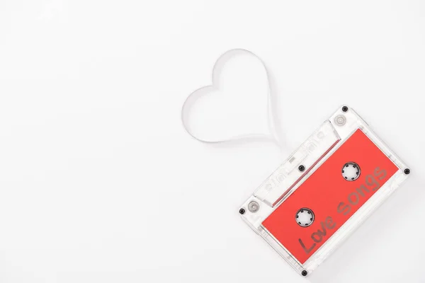 Draufsicht auf Audiokassette mit 'Liebesliedern' Schriftzug und Herz-Symbol isoliert auf weiß mit Kopierraum, Valentinstag-Konzept — Stockfoto