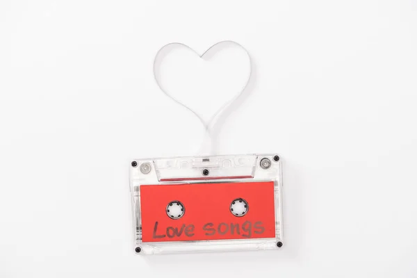 Top view of audio cassette with 'love songs' lettering and heart symbol isolated on white, st valentines day concept — Stock Photo