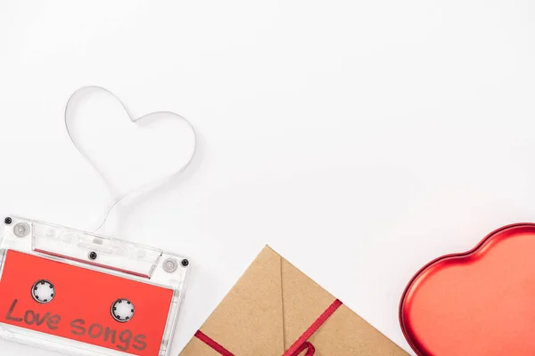 Vista superior de casete de audio con letras de 'canciones de amor' y símbolo del corazón aislado en blanco, San Valentín concepto de día - foto de stock