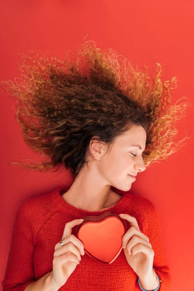 Vue du dessus de la belle fille tenant symbole de coeur isolé sur rouge, st concept de Saint-Valentin — Photo de stock
