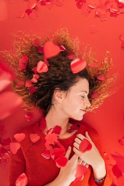 Draufsicht von Mädchen und fallendem herzförmigem Konfetti isoliert auf rotem, st Valentinstag Konzept — Stockfoto