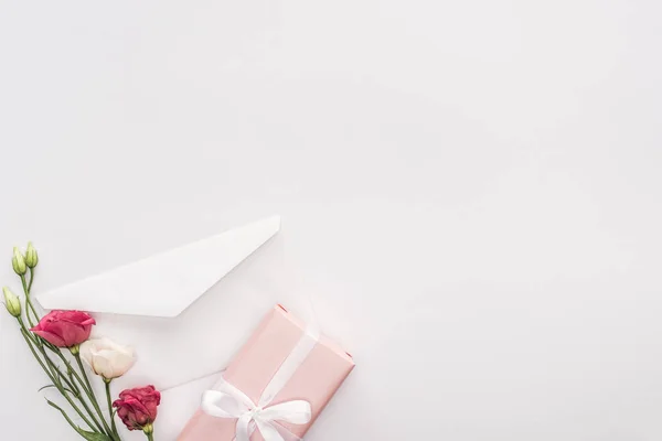 Vista superior de sobre, caja de regalo y flores aisladas en blanco — Stock Photo