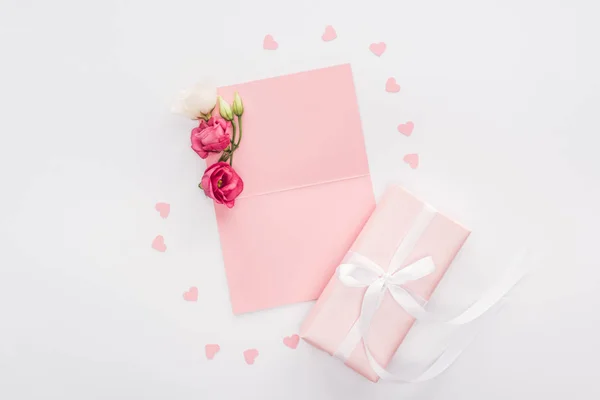 Vista superior de la tarjeta vacía, corazones de papel y caja de regalo aislada en blanco - foto de stock