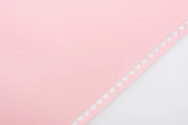 Fond de coeurs découpés en rang sur papier rose isolé sur blanc — Photo de stock