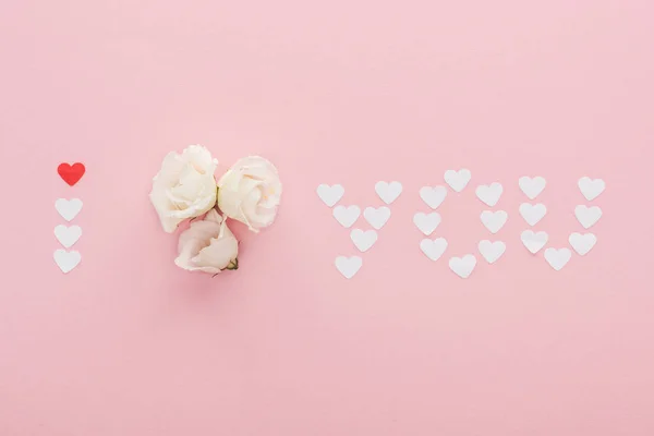 Draufsicht auf 'i love you' Schriftzug aus Papierherzen und Blumen isoliert auf rosa, Valentinstag-Konzept — Stockfoto