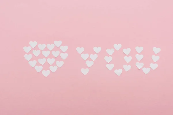 Vista dall'alto di 'ti amo' fatta di cuori di carta isolati su rosa, concetto giorno st valentines — Foto stock
