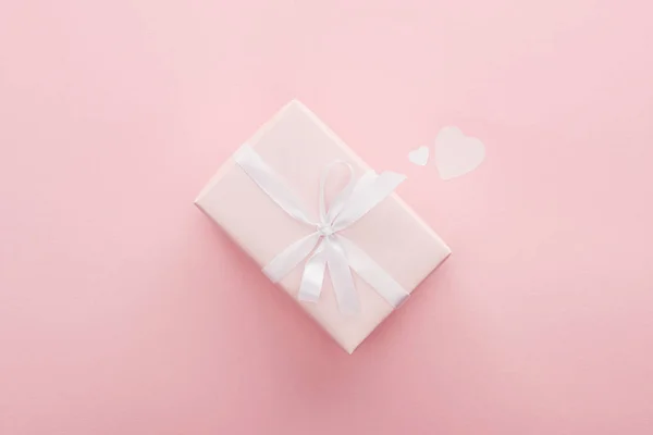 Top view of gift box and paper hearts isolated on pink — Stock Photo