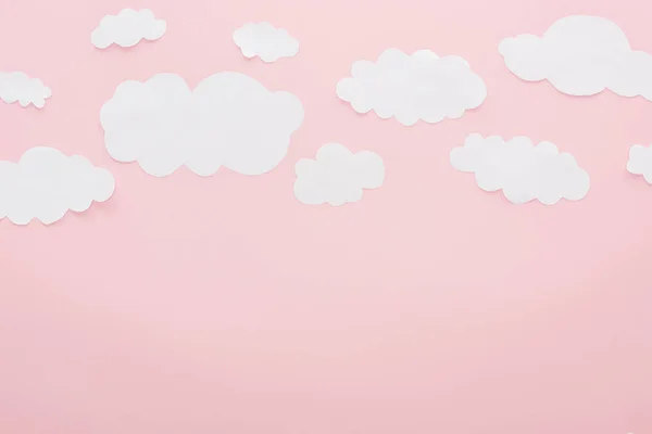 Top view of white paper clouds isolated on pink with copy space — Stock Photo