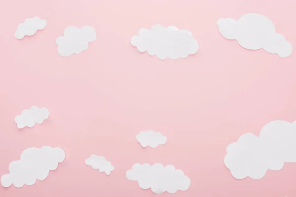 Top view of white paper clouds isolated on pink with copy space — Stock Photo