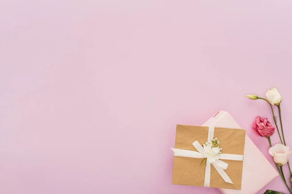Vista superior de cajas de regalo y flores aisladas en rosa con espacio de copia - foto de stock