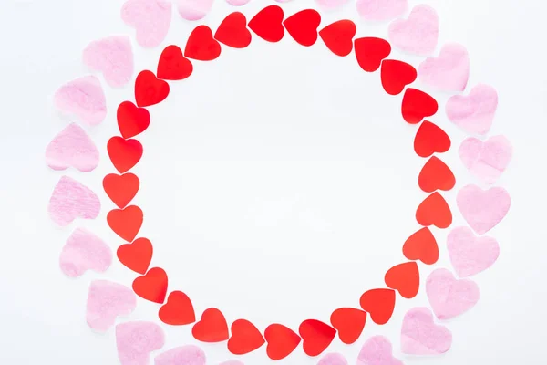 Vue du dessus du cadre rond fait de coeurs en papier rouge et rose isolés sur blanc, concept St Valentin — Photo de stock