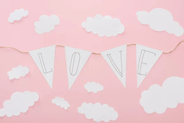 Top view of paper garland with 'love' lettering isolated on pink, st valentines day concept — Stock Photo