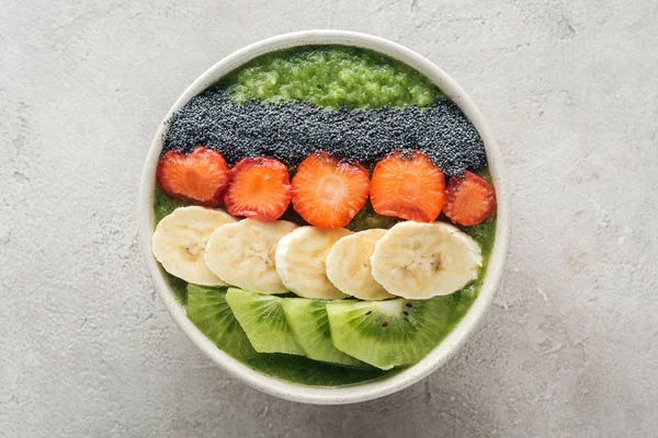 Vista superior de deliciosa tigela de smoothie com frutas frescas em fundo cinza — Fotografia de Stock