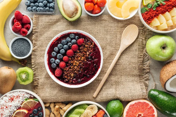 Top view of smoothie bowls and frame made of fresh organic ingredients on sackcloth — Stock Photo