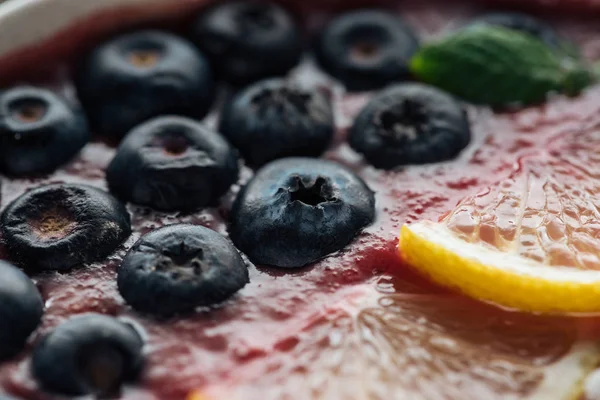 Close up of blueberries and sliced lemons in smoothie bowl — Stock Photo