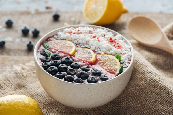 Selective focus of smoothie bowl with fresh fruits on sackcloth — Stock Photo