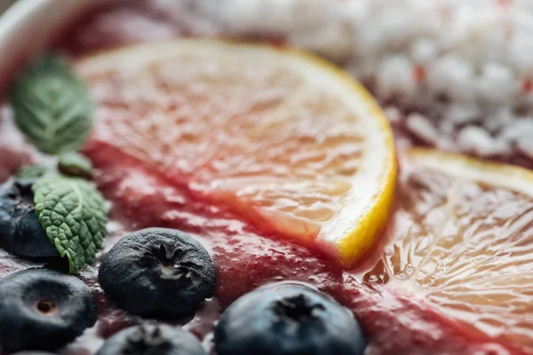 Close up of blueberries, mint and sliced lemons in smoothie bowl — Stock Photo