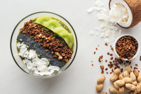 Vue du dessus du bol de smoothie vert sain avec des ingrédients sur fond blanc — Photo de stock