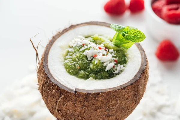 Свежий зеленый смузи в кокосовом орехе украшенный мятой — стоковое фото