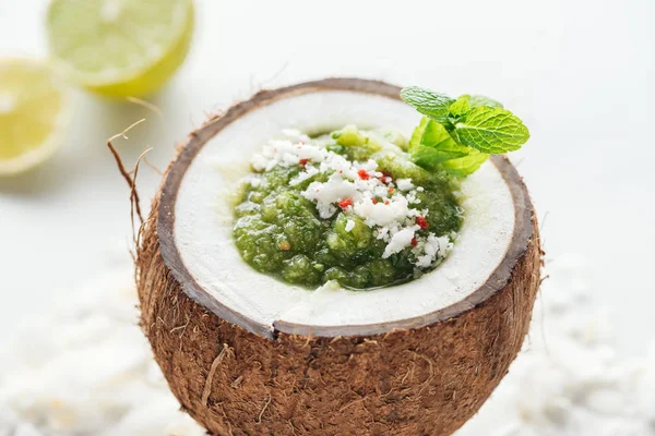 Селективний фокус свіжої зеленої смузі в кокосовому горіху, прикрашеному м'ятою — стокове фото