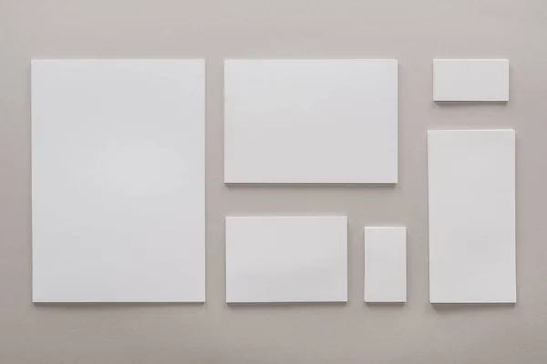 Vista superior de papéis vazios e cartões com espaço de cópia em fundo cinza — Fotografia de Stock
