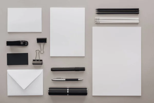 Flache Liege mit schwarz-weißer Schreibwaren am Arbeitsplatz auf grauem Hintergrund — Stockfoto