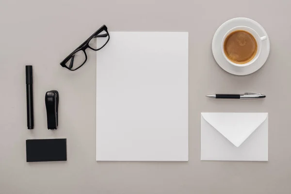 Vista superior de material de escritório no local de trabalho com xícara de café em fundo cinza — Fotografia de Stock