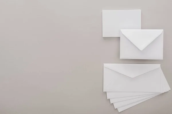 Top view of white envelopes on grey background with copy space — Stock Photo