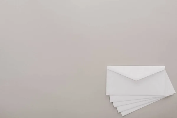 Vista superior de envelopes brancos sobre fundo cinza — Fotografia de Stock