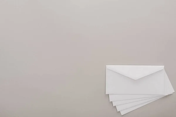 Vue de dessus des enveloppes blanches sur fond gris — Photo de stock