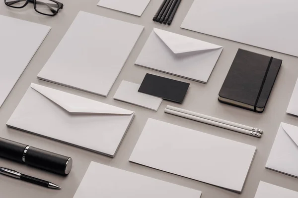 Flat lay with white and black stationery on grey background — Stock Photo