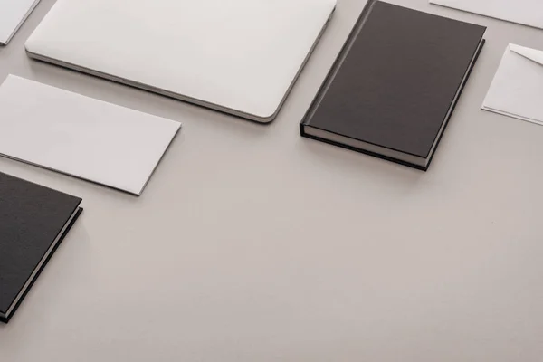 Black and white stationery and laptop on grey background — Stock Photo