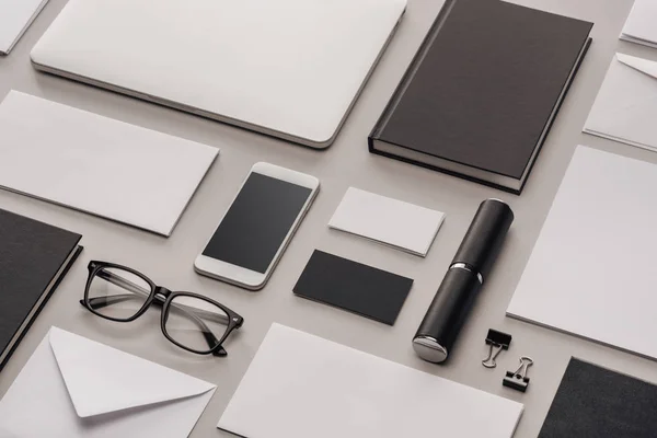 Plat avec gadgets et fournitures de bureau sur fond gris — Photo de stock