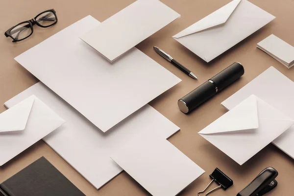 Lunettes, feuilles de papier, cartes, stylo, cahier, agrafeuse sur fond beige — Photo de stock