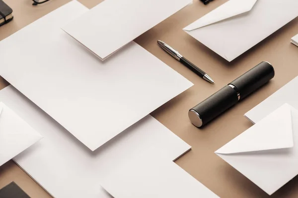 Pen, case, envelopes and sheets of paper on beige background — Stock Photo